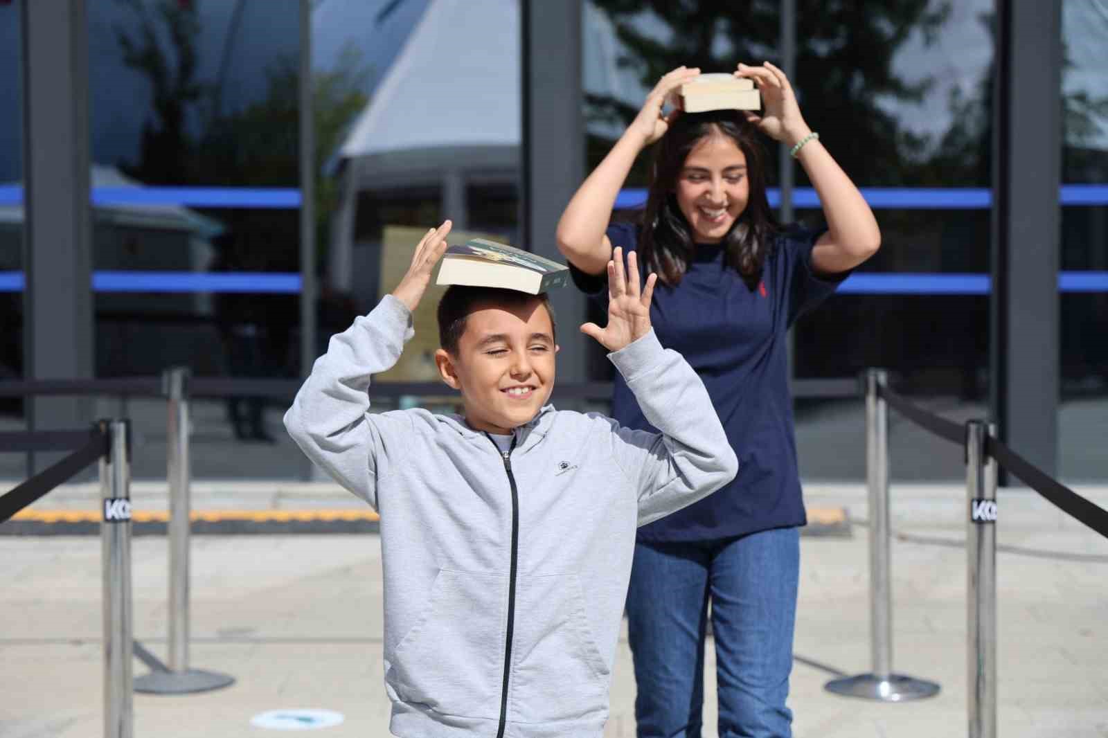 Kitap sevgisi bu kez denge oyununa dönüştü: En sevdiklerini başlarının üstünde taşıdılar

