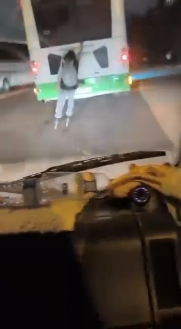 Otobüsün arkasına tutunarak patenle yolculuk etti
